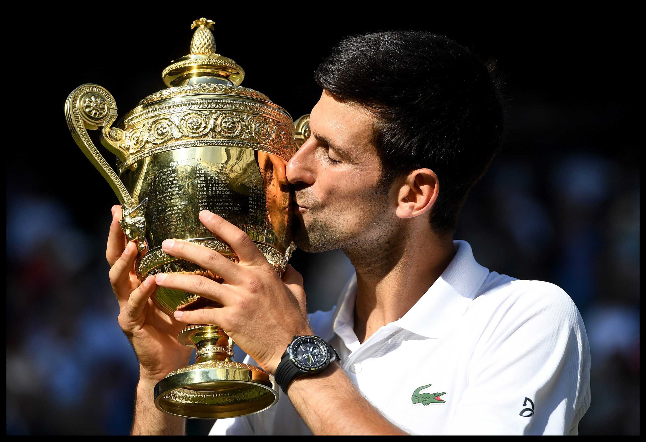 Novak Djokovic of Serbia celebrates with the trophy after winning his fourth Wimbledon by beating Kevin Anderson in the Mens Final on Centre court on Day Thirteen of the Wimbledon Tennis Championships on Sunday, July 15, 2018 in London, England. (Andrew Parsons/i-Images/Zuma Press/TNS)