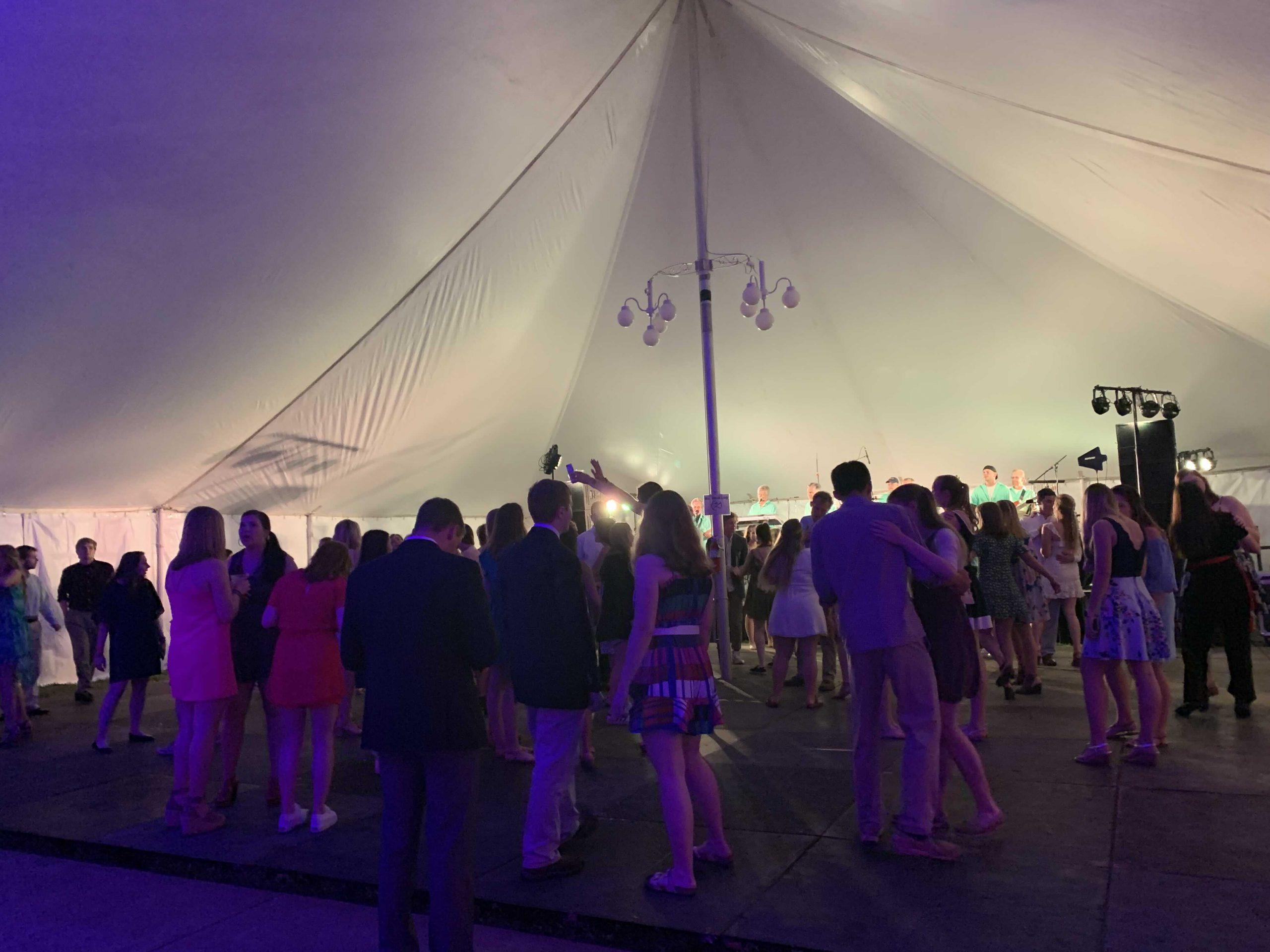 A photograph of a party inside a tent.