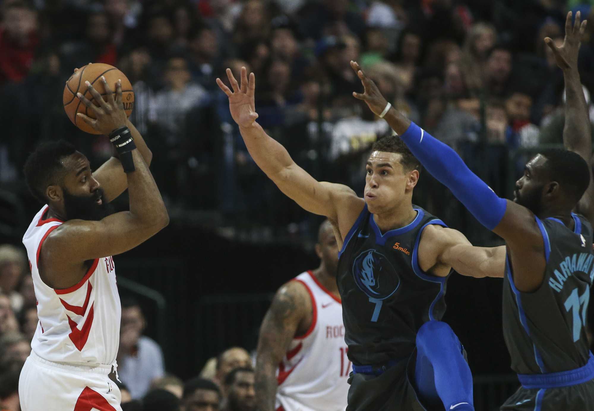 Dallas Mavericks forward Dwight Powell (7) and guard Tim Hardaway Jr. (11) work to stop Houston Rockets guard James Harden (13) during the first half on Sunday, March 10, 2019 at the American Airlines Center in Dallas, Texas. (Ryan Michalesko/Dallas Morning News/TNS)