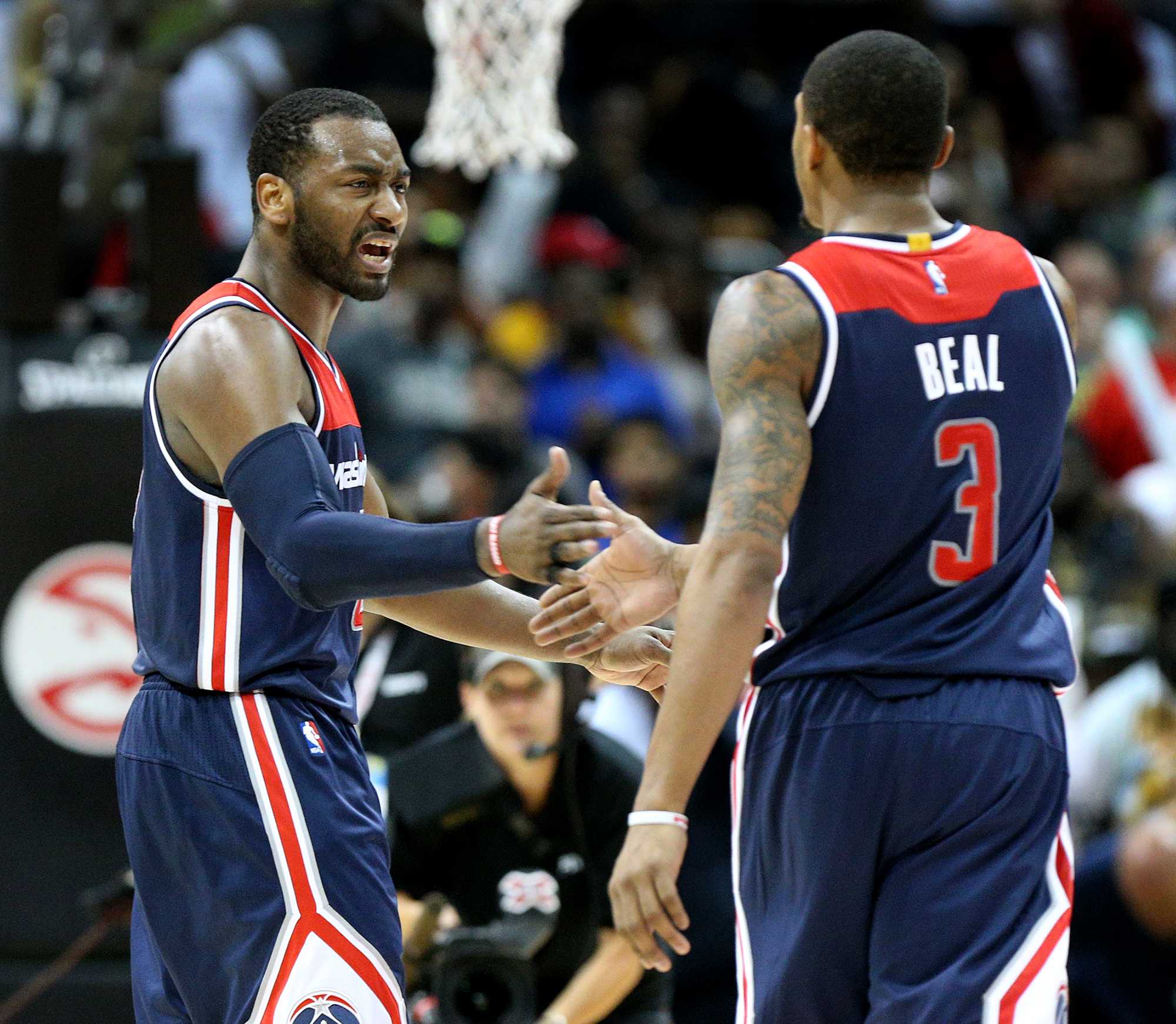 The Washington Wizards John Wall, left, and Bradley Beal (3) celebrate a 115-99 series-clinching victory against the Atlanta Hawks in Game 6 of the Eastern Conference quarterfinals on Friday, April 28, 2017, at Philips Arena in Atlanta. (Curtis Compton/Atlanta Journal-Constitution/TNS)