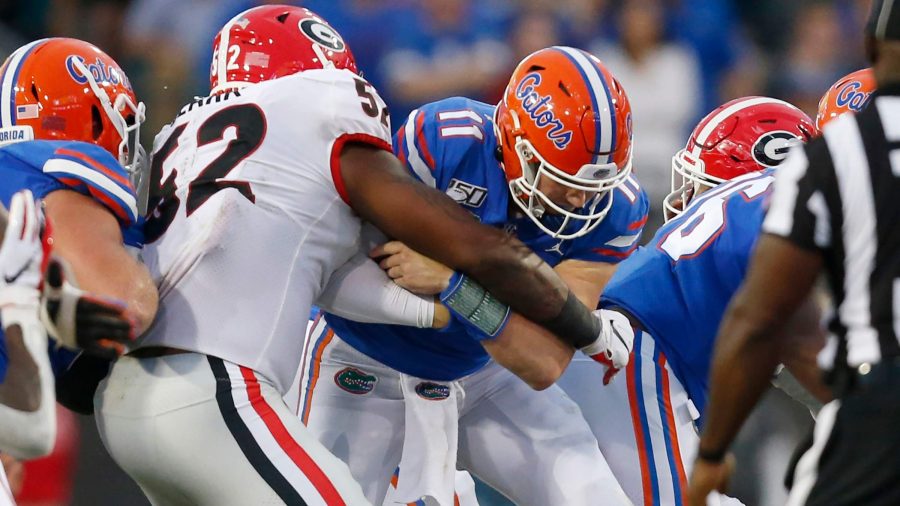 Florida Gators quarterback Kyle Trask (11) is tackled by Georgia Bulldogs defensive lineman Tyler Clark  while scrambling to get a first down during the second half of the game at TIAA Bank Field in Jacksonville, Florida on Saturday, November 2, 2019.  OCTAVIO JONES  |  Times