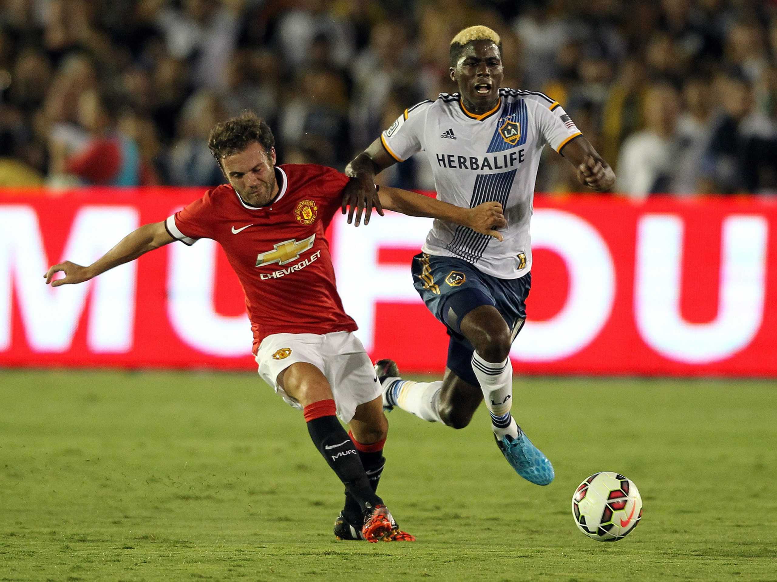 Manchester Uniteds Juan Mata, left, and the Los Angeles Galaxys Gyasi Zardes fight for the ball in an exhibition game at the Rose Bowl in Pasadena, Calif., on Wednesday, July 23, 2014. Manchester won, 7-0. (Rick Loomis/Los Angeles Times/MCT)