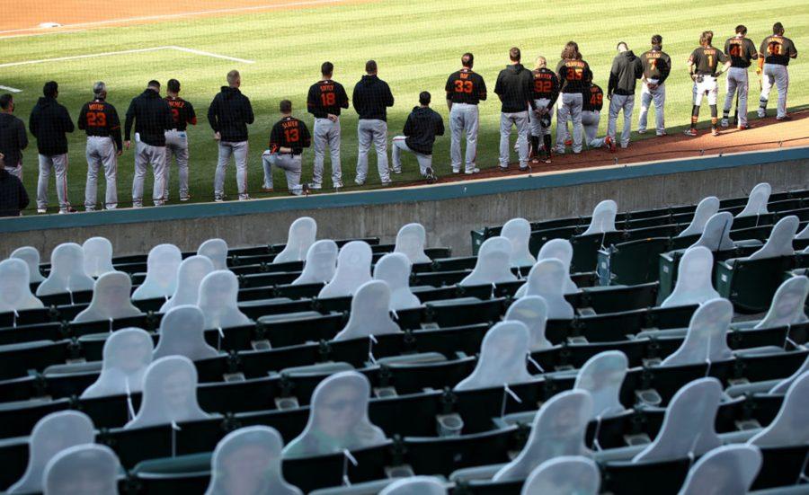 Austin Slater #13 and Jaylin Davis #49 of the San Francisco Giants kneel during the National Anthem before their exhibition game against the Oakland Athletics at Oakland-Alameda County Coliseum on July 20, 2020 in Oakland, California. (Photo by Ezra Shaw/Getty Images/TNS)