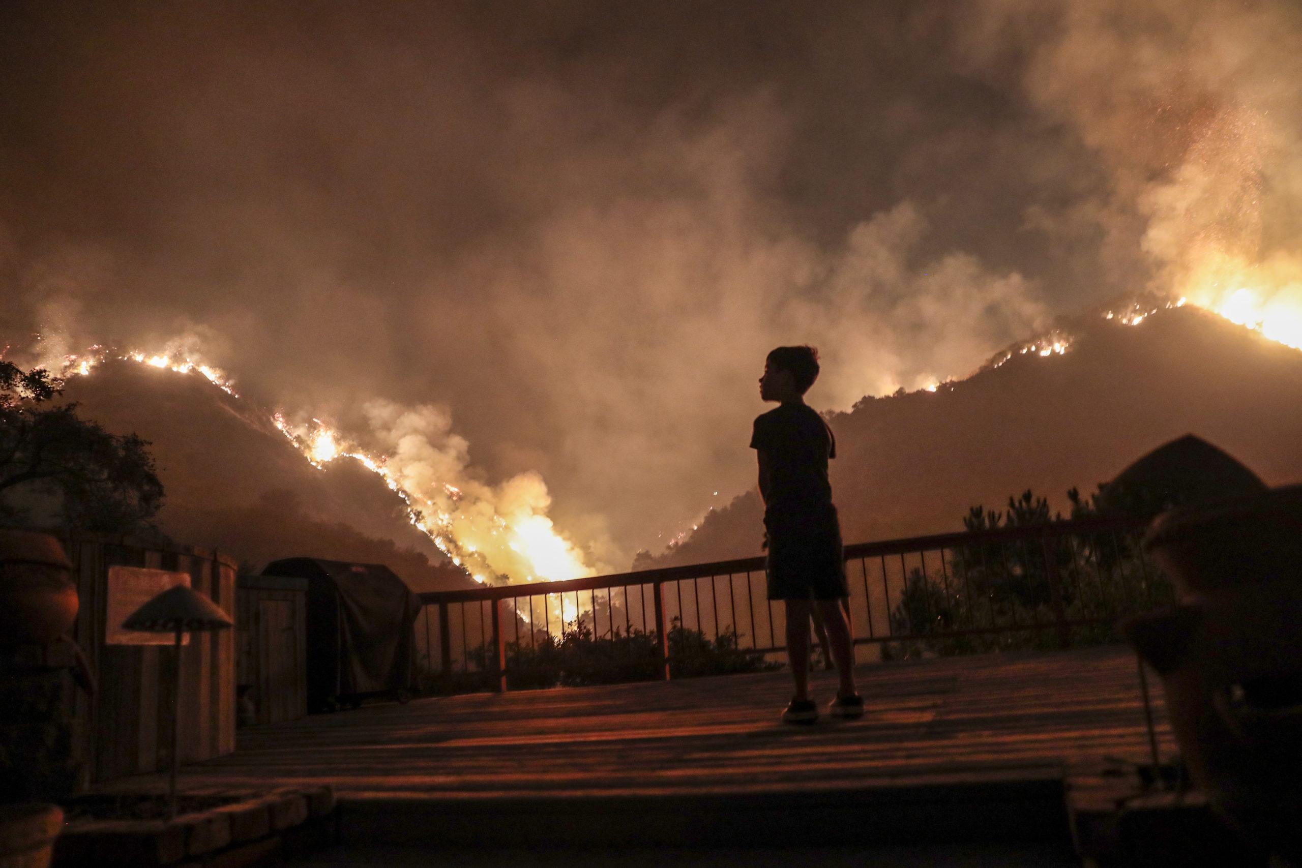 Monrovia, CA, September 15, 2020 - Castle Snider, 8, looks on as flames engulf the hillsides behind his backyard as the Bobcat Fire burns near homes on Oakglade Dr. (Robert Gauthier/ Los Angeles Times/TNS)