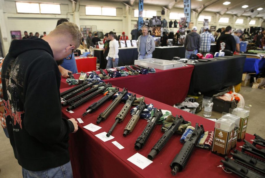 Gun aficionados observe parts of AR-15 semi-automatic rifles at a marketplace in California. The AR-15 has been at the center of the gun-control debate because this weapon has been used to commit atrocities. 