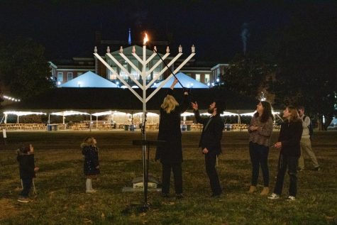 President Susan Wente lights the middle candle of the menorah on Manchester Plaza Monday night.