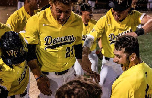 Redshirt junior Michael Turconi celebrates with his teammates at home plate after hitting a walk-off home run in Saturday’s extra-inning victory.