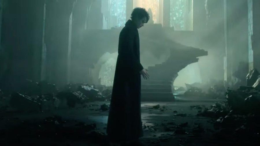 A still from The Sandman in which a character stands in an eerily-lit room.