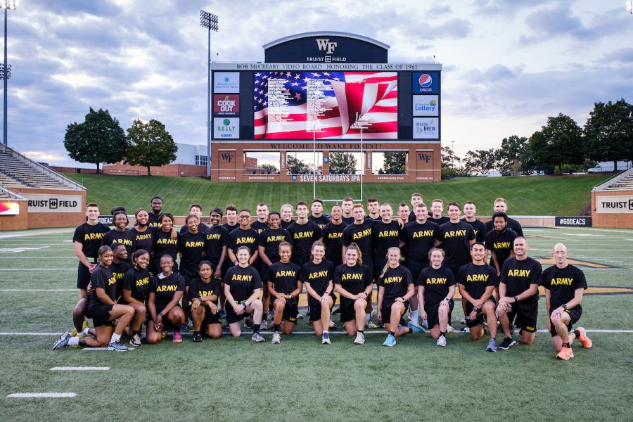 A+photograph+of+a+group+of+people+in+black+shirts+on+a+football+field