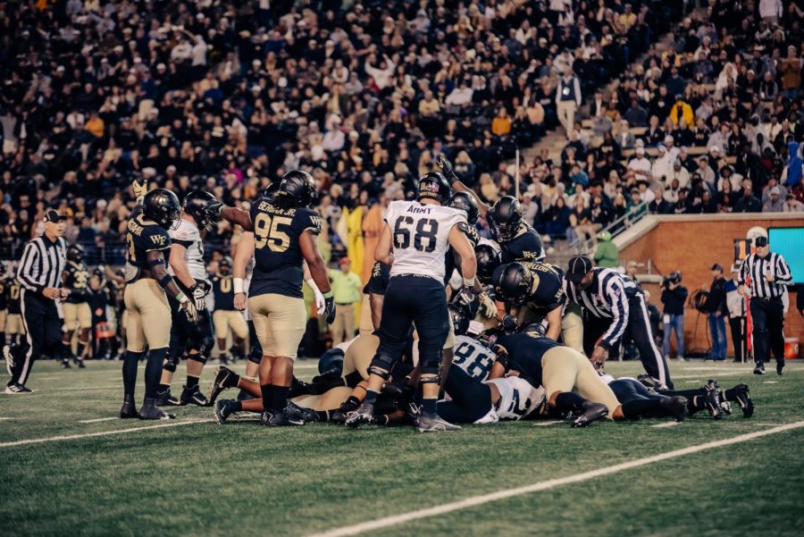 Members of the Wake Forest defense point to the Wake Forest end zone after a fumble recovery.