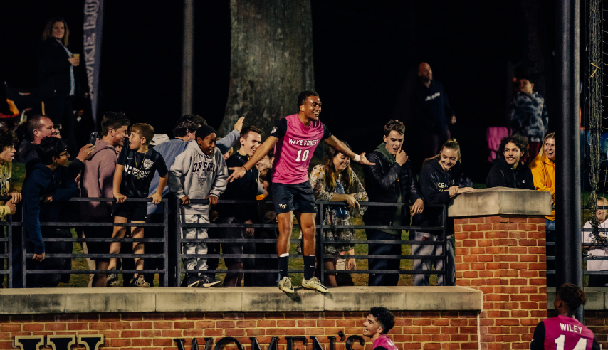 Junior midfielder Oscar Sears (No.10 in pink) celebrates with the crowd after scoring his second goal on the night against Boston College.