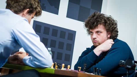 Hans Niemann (right) defeats Magnus Carlsen (left) in a chess match.