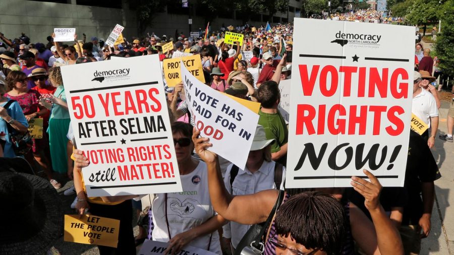 Protestors march against voter suppression, carrying signs that call back to the Civil Rights Movement.
