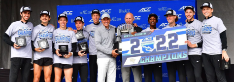 The Wake Forest mens cross country team poses with the ACC Championship trophy.