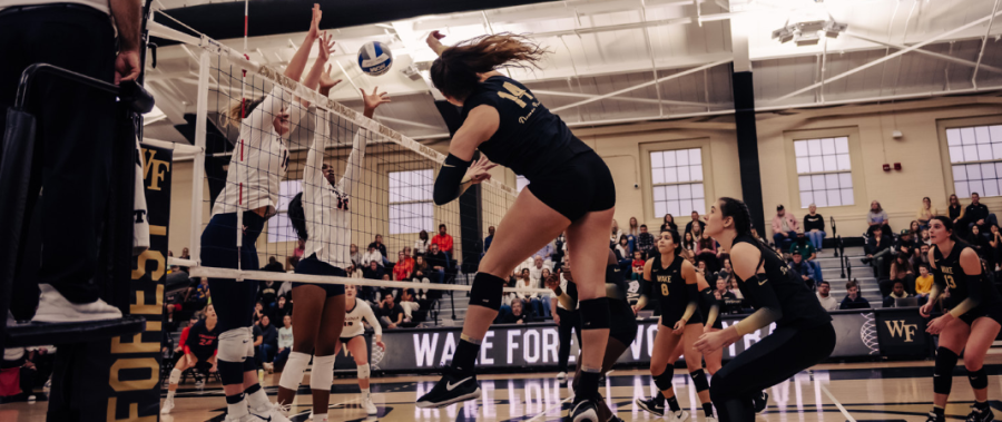 Junior outside hitter Ashley Slater (No. 14 in black) sends down a powerful strike on the Cavaliers. Slater led Wake Forest in kills with 10.