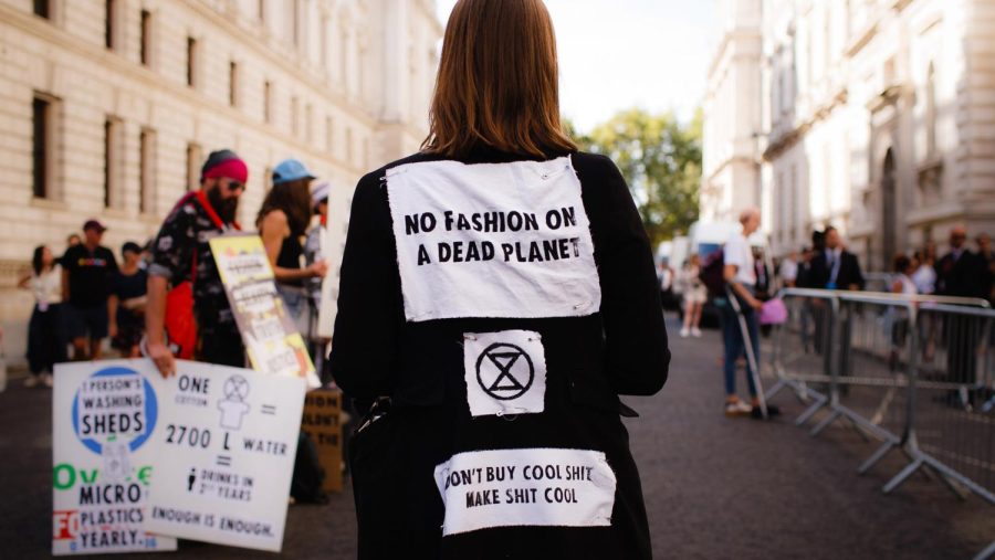 A protestor wears anti-fashion messages on their clothes.
