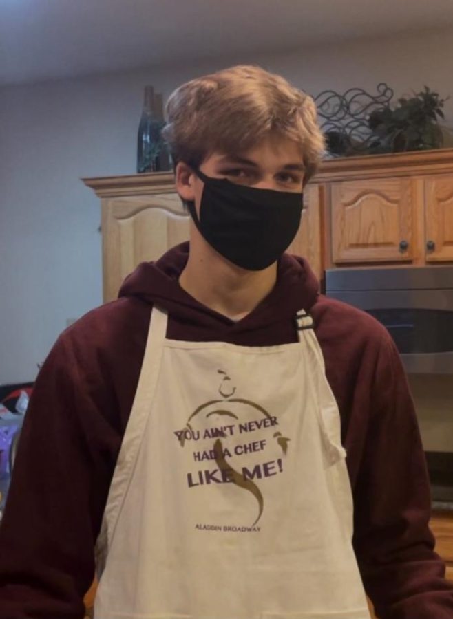 Adam Coil, donning a mask and apron, poses during the COVID pandemic.