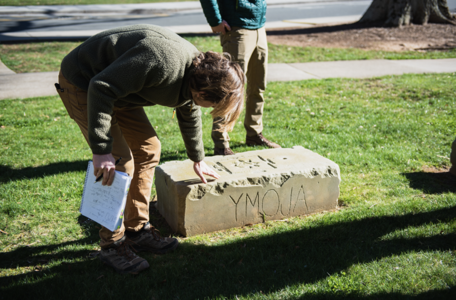 A student touches one of the rocks part of a meditation circle in between ZSR and Babcock and Luter Hall. 