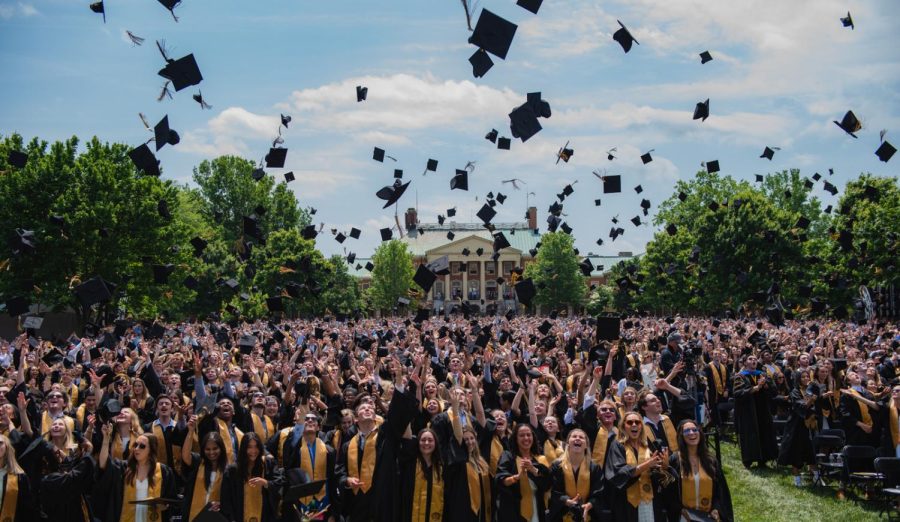 Graduates throw their caps into the air.