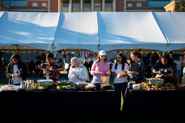 Students line up for an array of cultural dishes from around the world, including foods like southern barbecue and sushi.