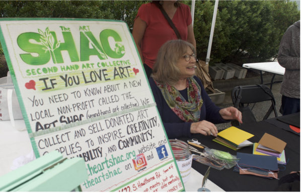SHAC volunteers lead sustainable notebook-making tutorial at a public engagement booth.