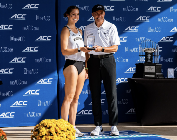 Brooke Wilson receives All-ACC honors from conference commissioner Jim Phillips after finishing in 18th place with a time of 20:21.1.