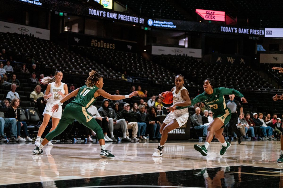 Kaia Harrison tries to drive to the basket past two reaching Charlotte defenders. The graduate guard finished the night with 11 points, four assists and four steals. (Courtesy of Wake Forest Athletics)
