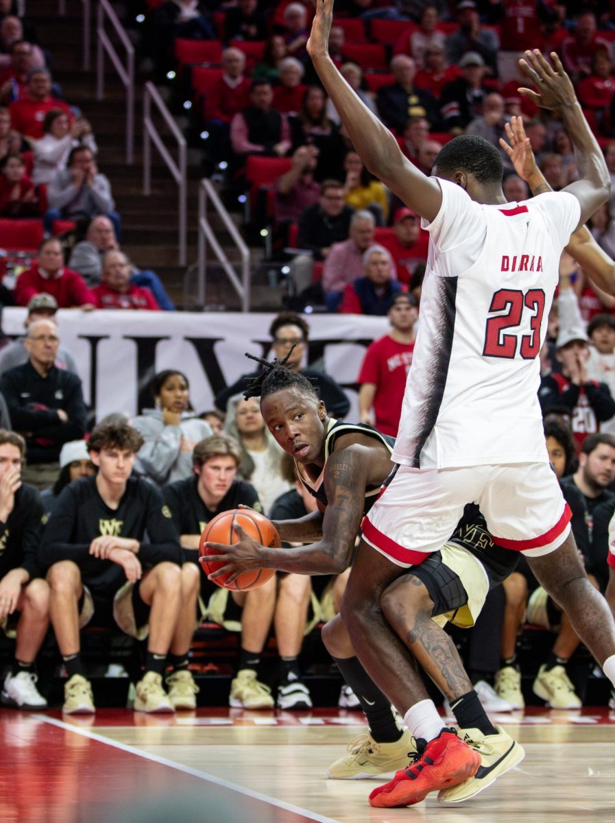 Kevin “Boopie” Miller (0) looks for an opportunity to pass around NC State’s Mohamed Diarra (23).