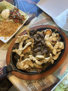 A sizzling cast iron of chicken, shrimp, vegetable and steak fajitas sit on the table at Xcaret Mexican Grill and Cantina. (Courtesy of Melina Traiforos)