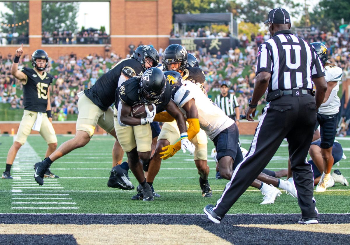 Cameron Hite (20) and Horatio Fields Jr. (5) block NC A&T defense to make an opening for Demond Claiborne (1) to obtain a touchdown.