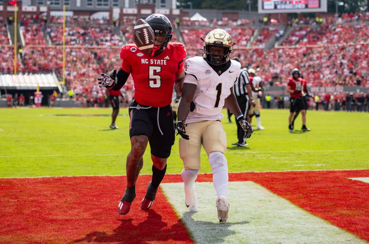 Wake Forest running back Demond Claiborne (1) struggles with NC State safety DK Kaufman (5) for a ball in the endzone.