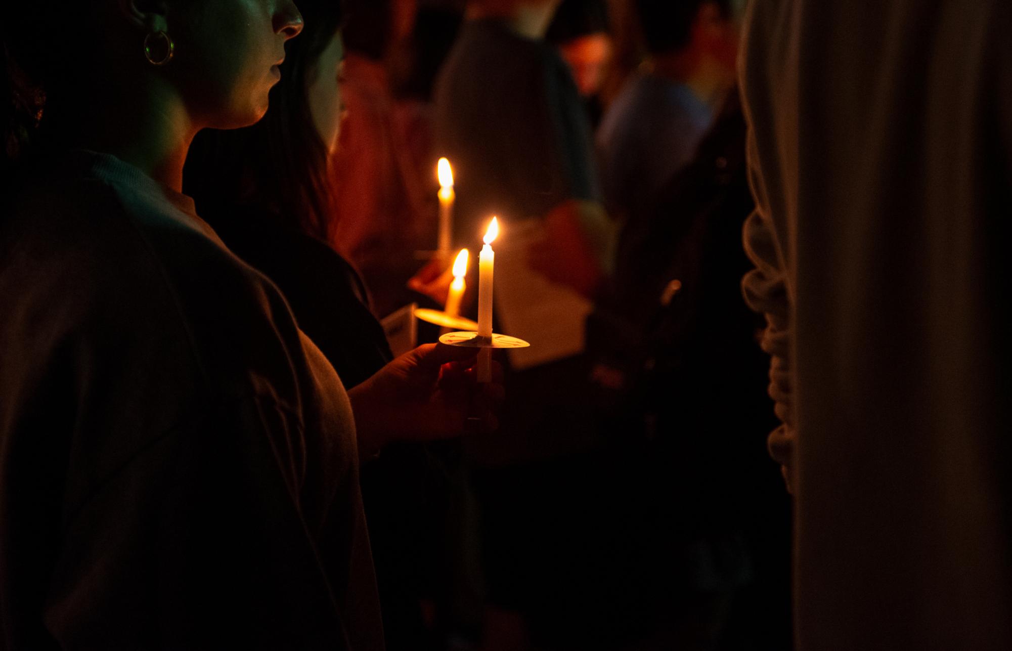 A student holds a candle at an evening memorial event on Oct. 7.