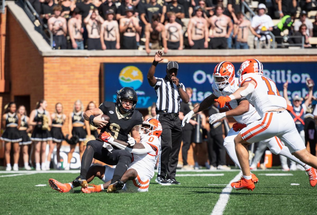 Wake Forest quarterback Hank Bachmeier (9) is sacked by Clemson linebacker Barrett Carter (0).