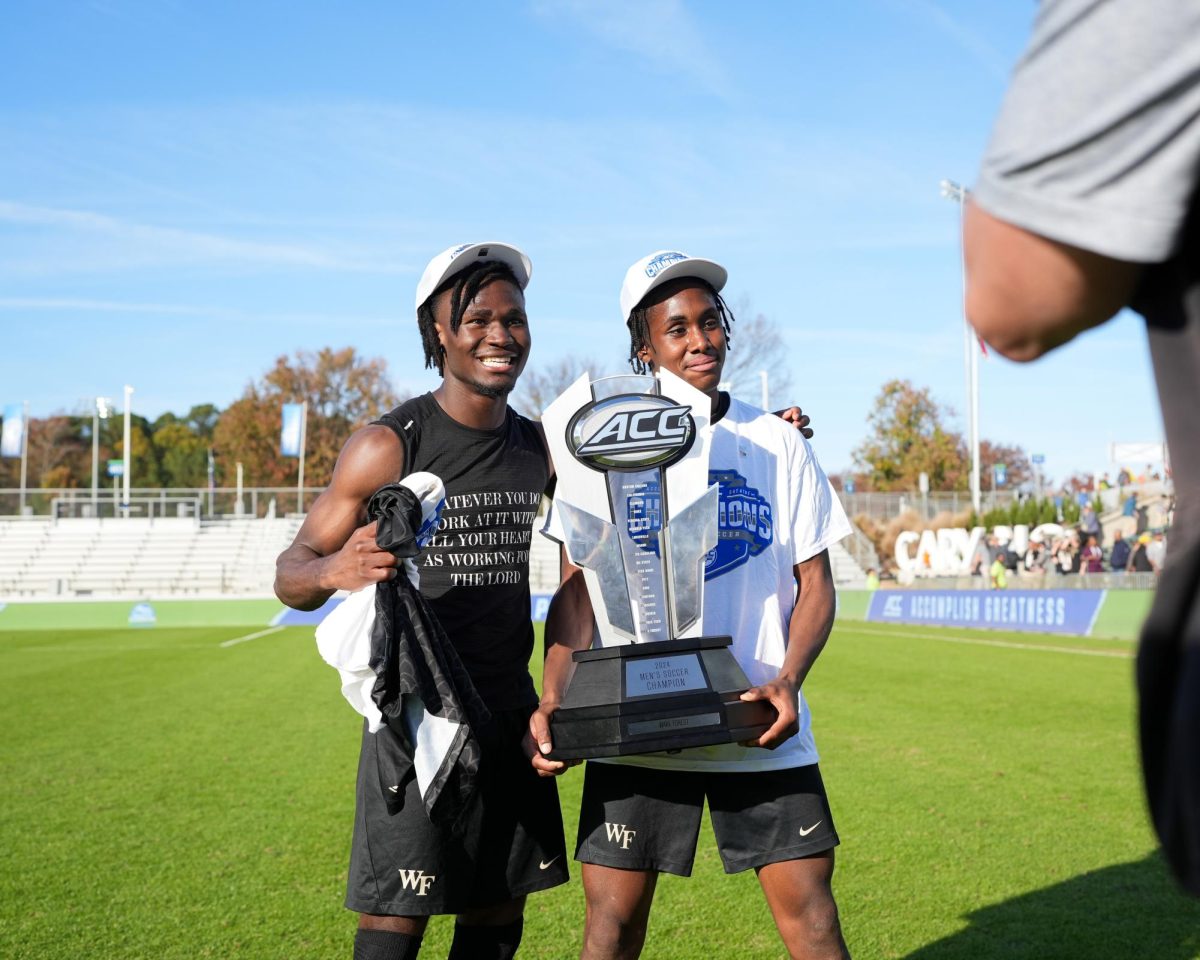 Bo Cummins (2) and Amoni Thomas (4) pose with the ACC Tournament Championship trophy.