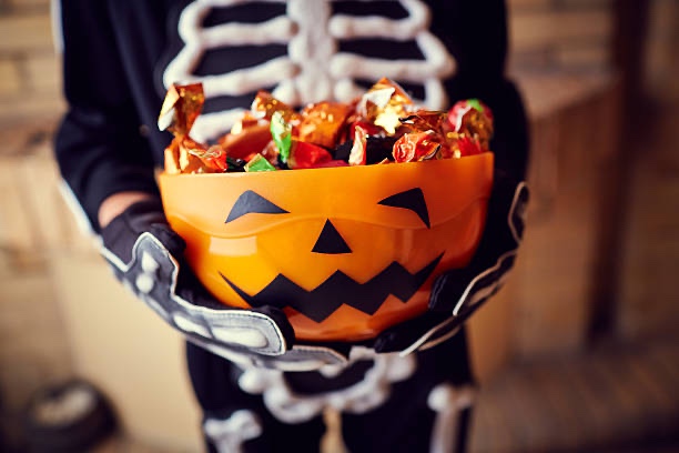 Another victim of the onesie epidemic, this time of skeletal variety, holding a candy bucket. (Courtesy of IStock)