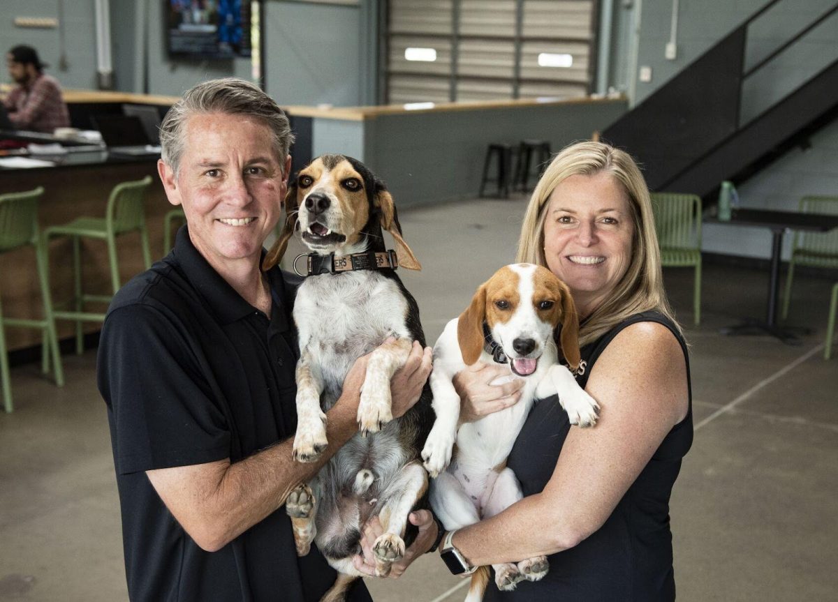 Cole and Kim Parsons holding their rescue dogs, Tucker and Millie.