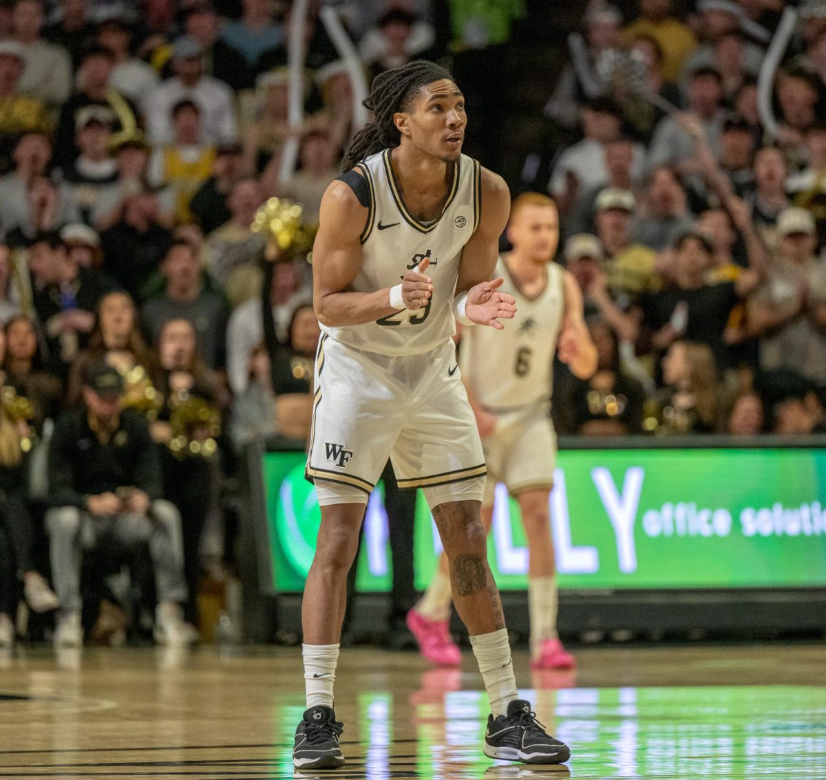 Eyeing the scoreboard, Hunter Sallis (23) claps it up after making a difficult two-point shot.