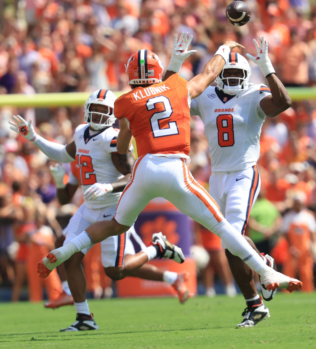 Cade Klubnik attempts to get rid of the ball as he is pressured by two Syracuse defenders. Courtesy of Syracuse Athletics.