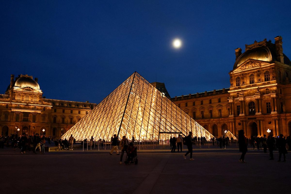 People walk near the glass Pyramid of the Louvre museum as French police have arrested more suspects linked to the theft of treasures from the Louvre museum's Galerie d'Apollon (Apollo gallery), in Paris, France, October 30, 2025. REUTERS/Abdul Saboor