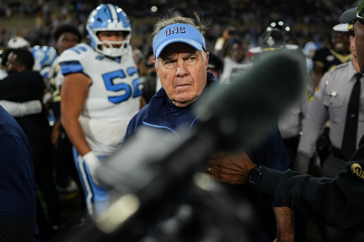 North Carolina head coach Bill Belichick walks off the field after a 28–12 defeat.