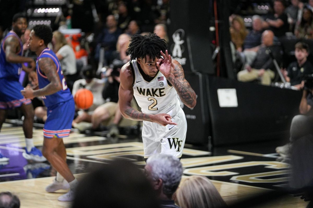 Juke Harris (2) celebrates and points towards the crowd after sinking a three-point shot.