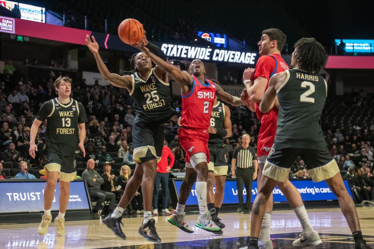 Tre'Von Spillers (25) battles for a rebound against former Demon Deacon, Boopie Miller (2).