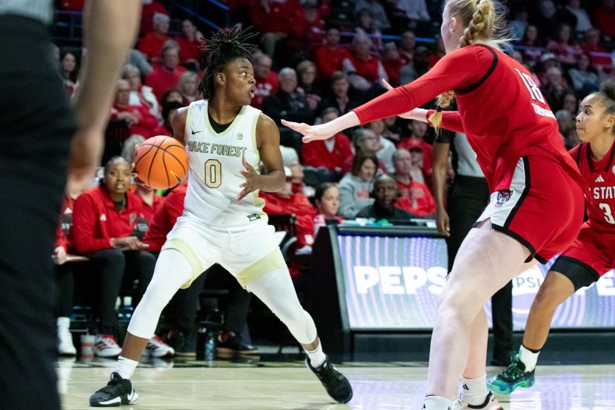 Freshman guard Milam Brown fends off an NC State defender during last Thursday's rivalry matchup.