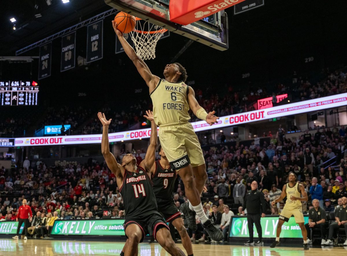 Myles Colvin (6) stretches up to the rim for a tough one-handed layup.