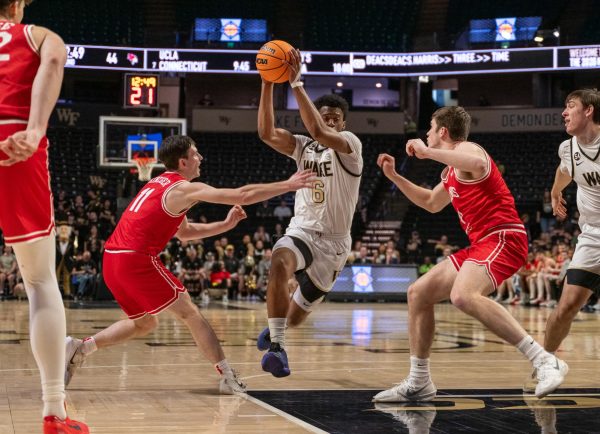 Myles Colvin (6) lifts the ball high into the air to avoid his opponent's attempted steal.