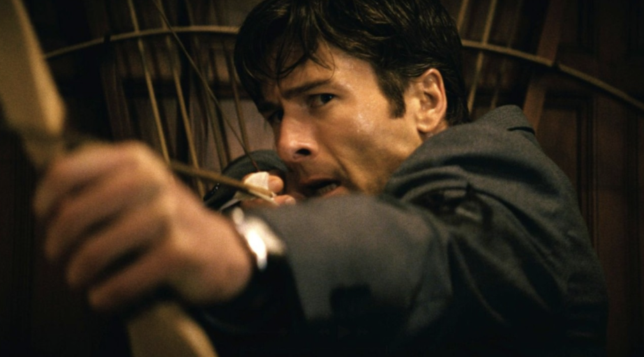 Glen Powell defends himself with a bow and arrows in the new thriller, “How to Make a Killing.” (Courtesy of the Hollywood Reporter)