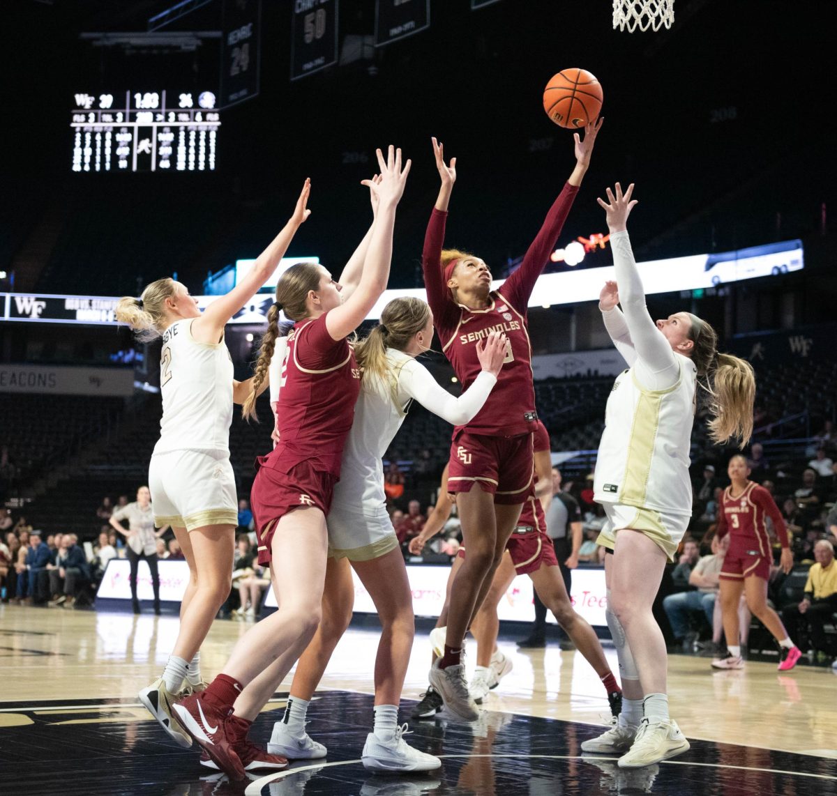 FSU's Tatum Greene (13) reaches towards the net as WFU's Emily Johns (44), Aurora Sørbye (2), and Opal Bird (9) attempt to block the shot.
