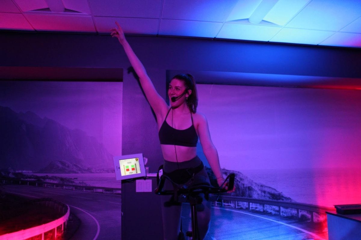 Senior Delaney Wiegel leads an indoor cycling class at the Reynolds Gymnasium, creating a positive and fun workout environment. (Courtesy of Delaney Wiegel)
